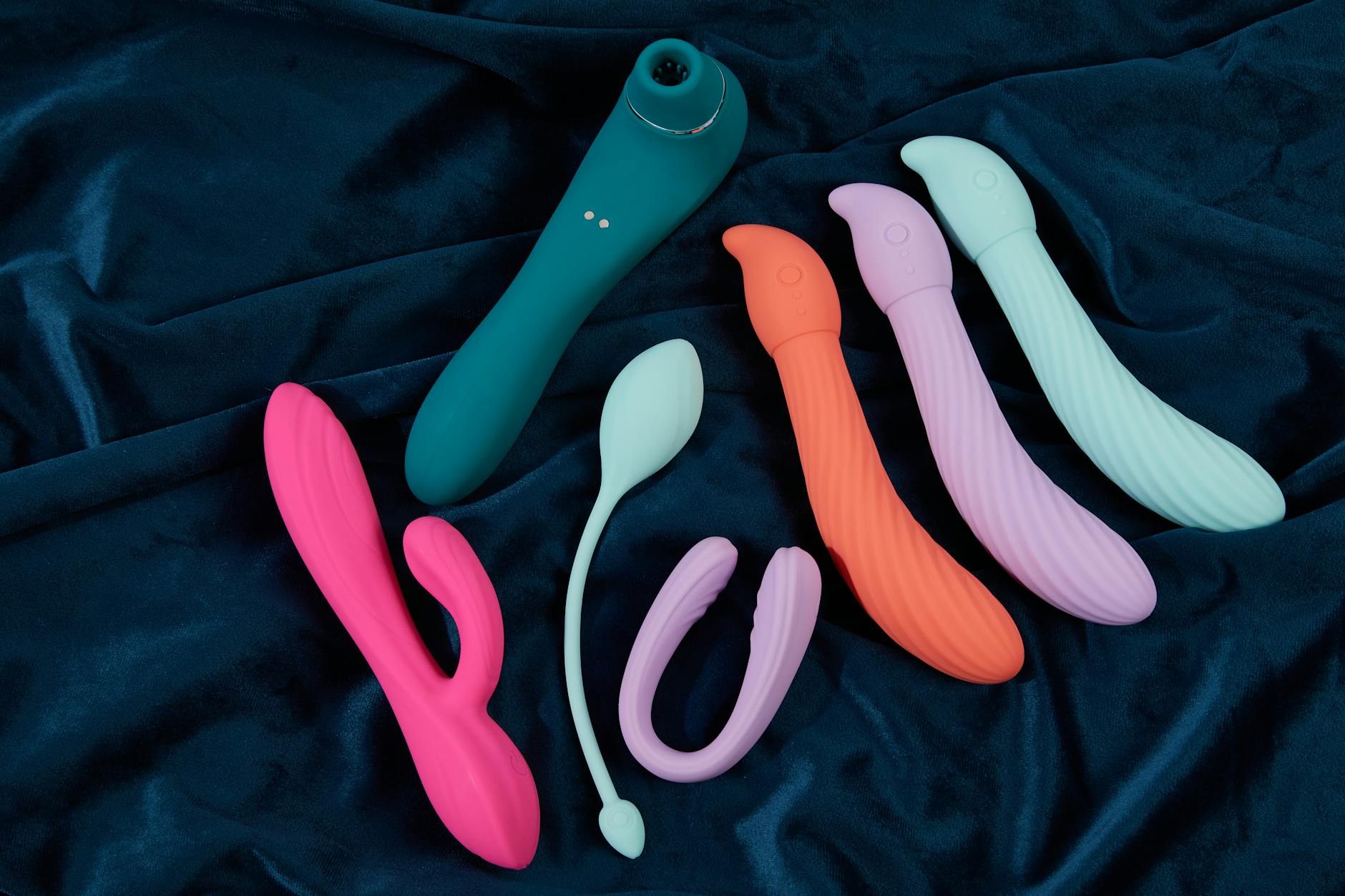 A blue silicone lemon vibrator held in hand against a solid purple background for self-pleasure