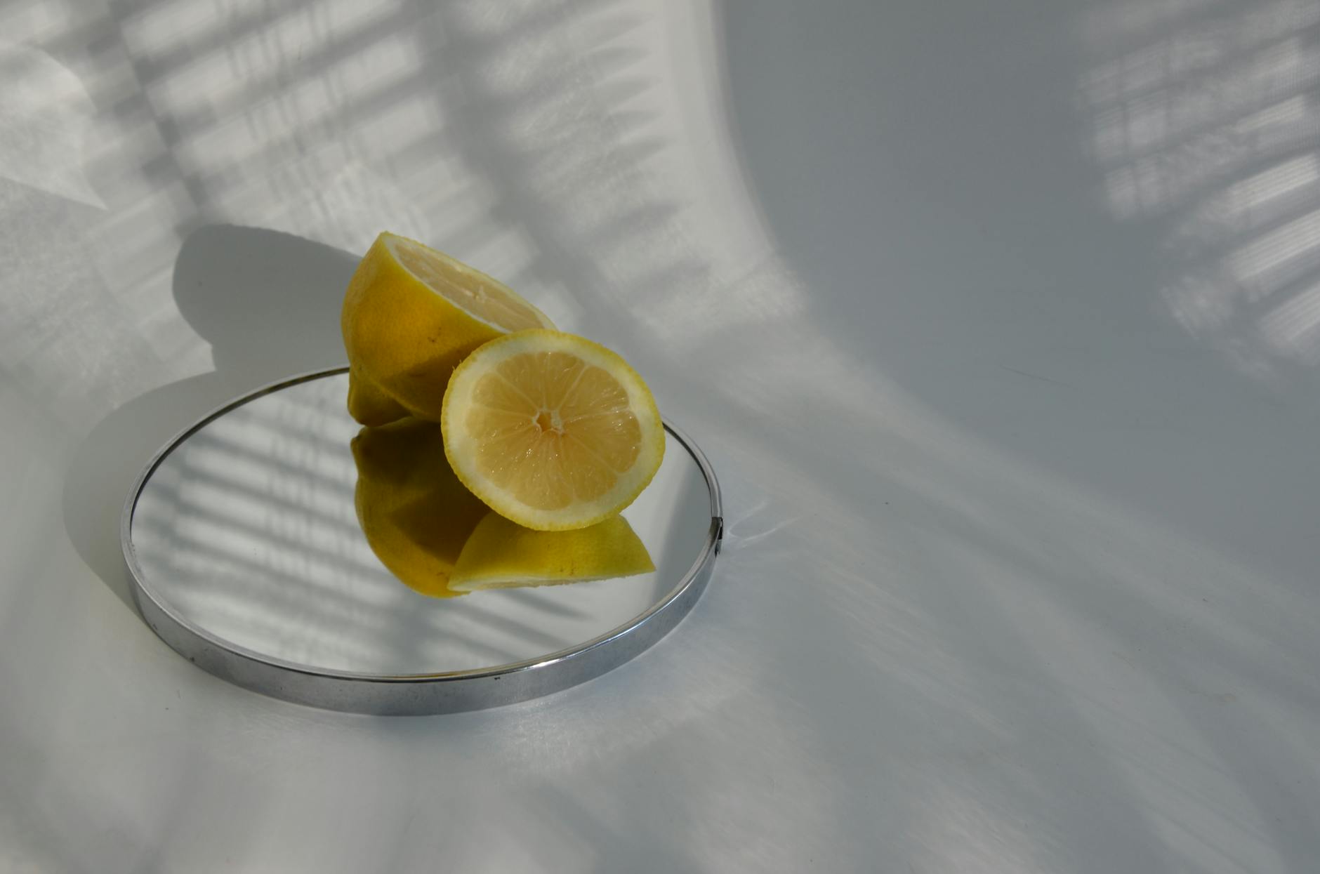 A hand holding a fresh lemon on a soft pink background, symbolizing gentle reconnection and awakening