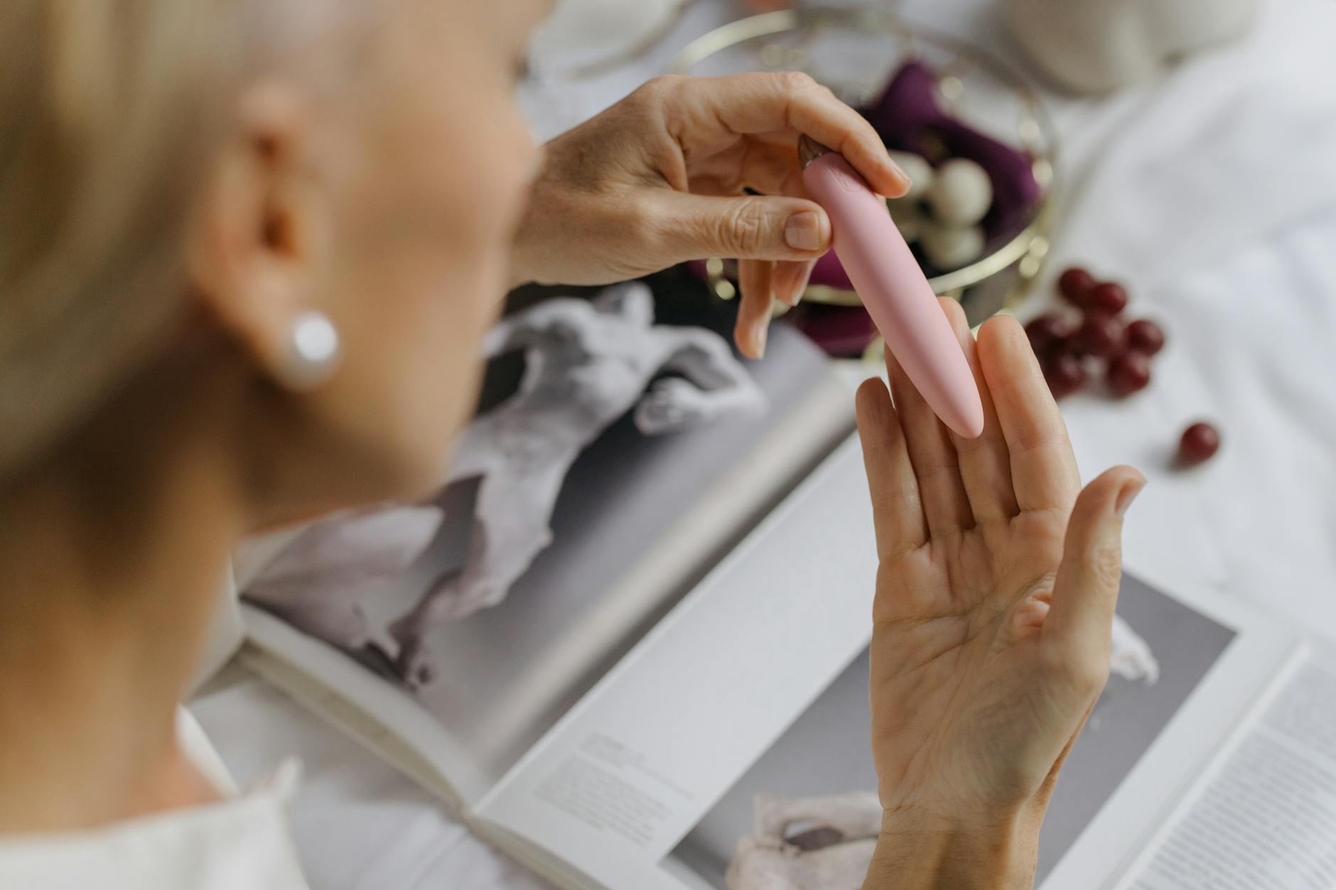 Close-up of hands holding a pink vibrator, personal pleasure and intimacy theme