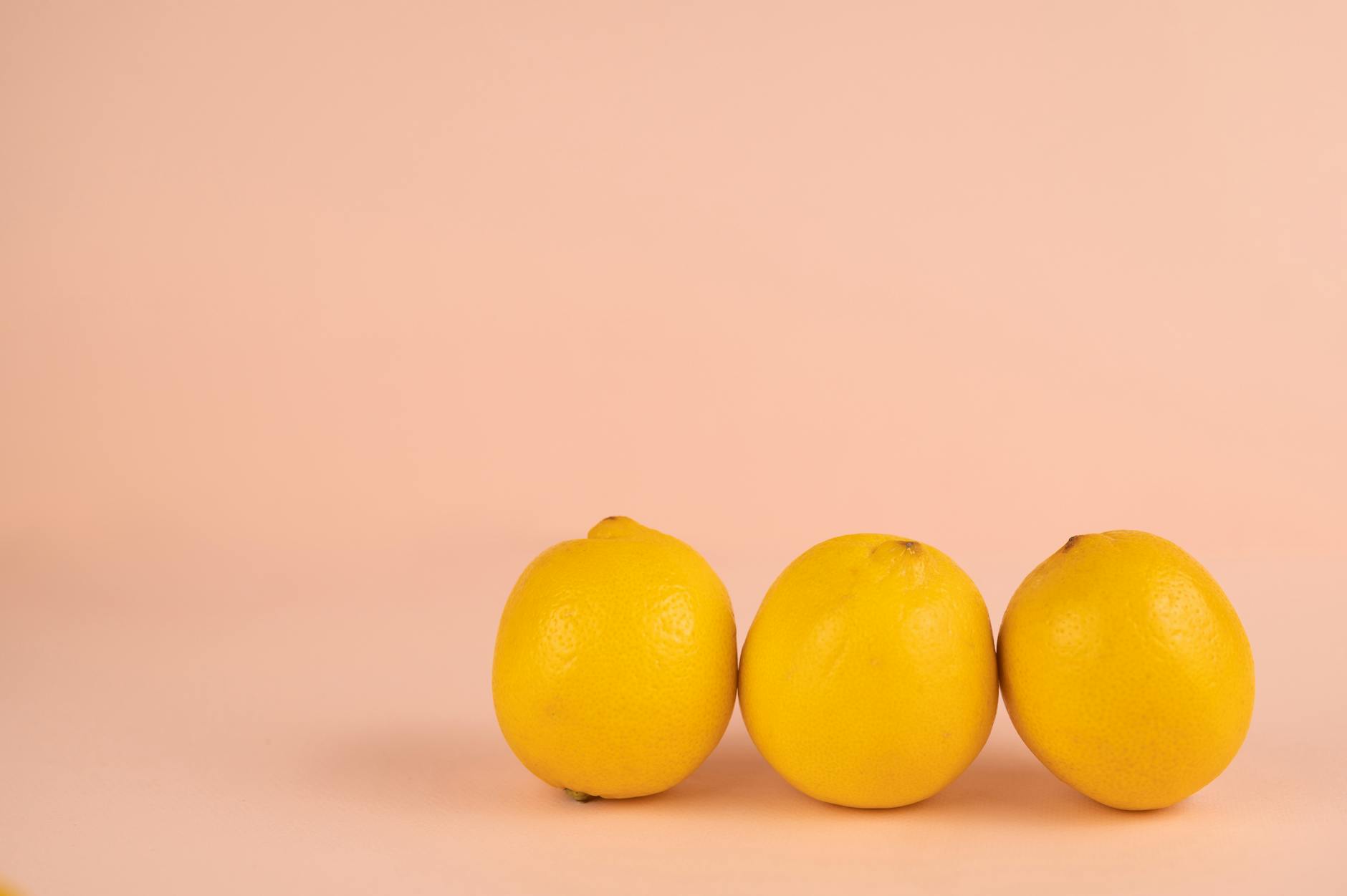 A close-up of a hand holding an orange vibrator against a minimalistic purple backdrop, showcasing modern sensuality.